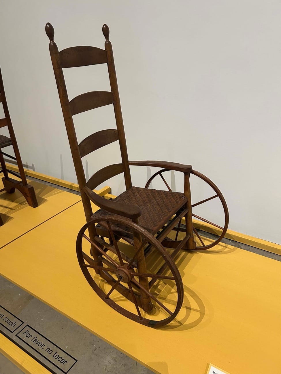 a beautiful wooden rocking chair has been transformed into a wheelchair for mobility purposes